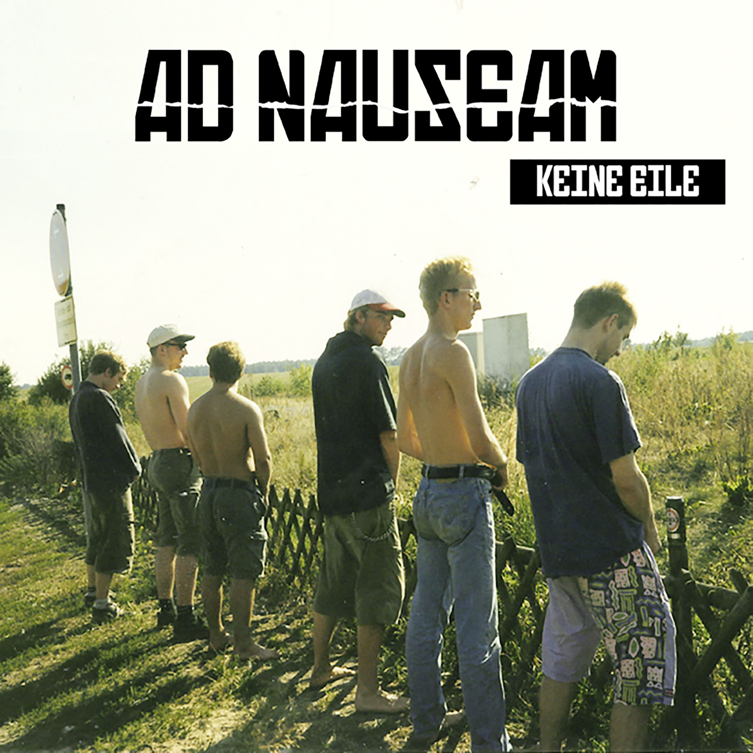Die Band Ad Nauesam pieselt in einer Reihe gegen einen Zaun.